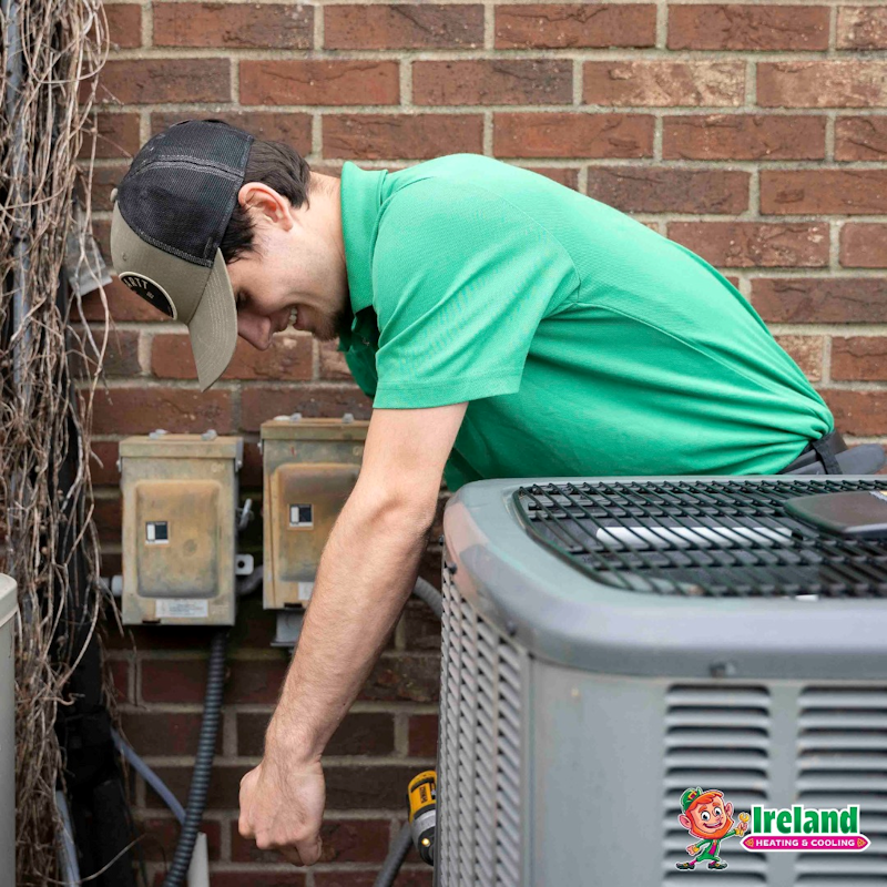 Ireland Heating and Cooling technician inspecting an outdoor heat pump unit